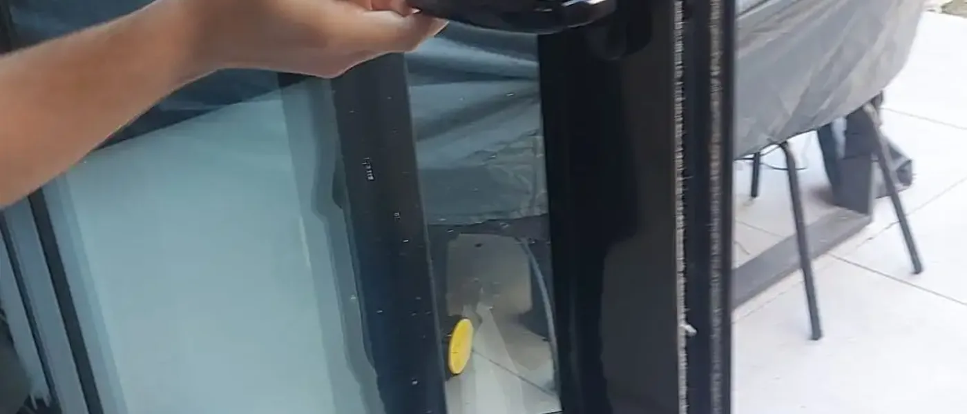 Close-up of a locksmith replacing a door lock cylinder on a modern sliding door in a London home
